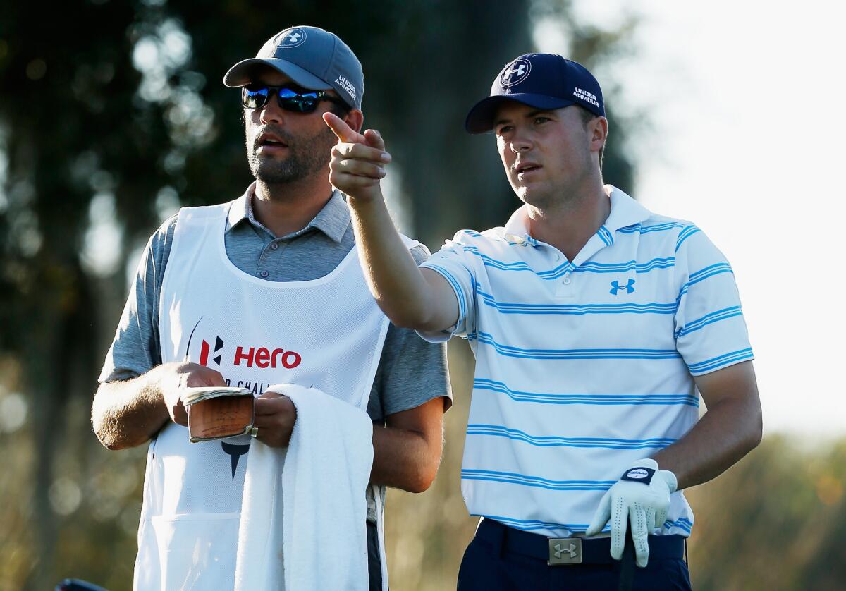 Jordan Spieth and caddie Michael Greller take a look at the yardage book and discuss Spieth's tee shot at No. 17 during the third round of the Hero World Challenge on Saturday.