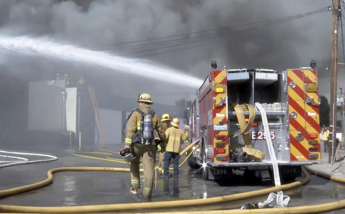 Los Angeles city firefighters work to extinguish a large commercial fire at marijuana grow warehouse in Canoga Park