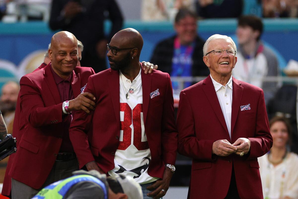 Former Washington Redskins coach Joe Gibbs, right, stands next to fellow Pro Football Hall of Famers Ronnie Lott, left, and Jerry Rice while being honored as part of the NFL's All-Time Team before Super Bowl LIV on Feb. 2.
