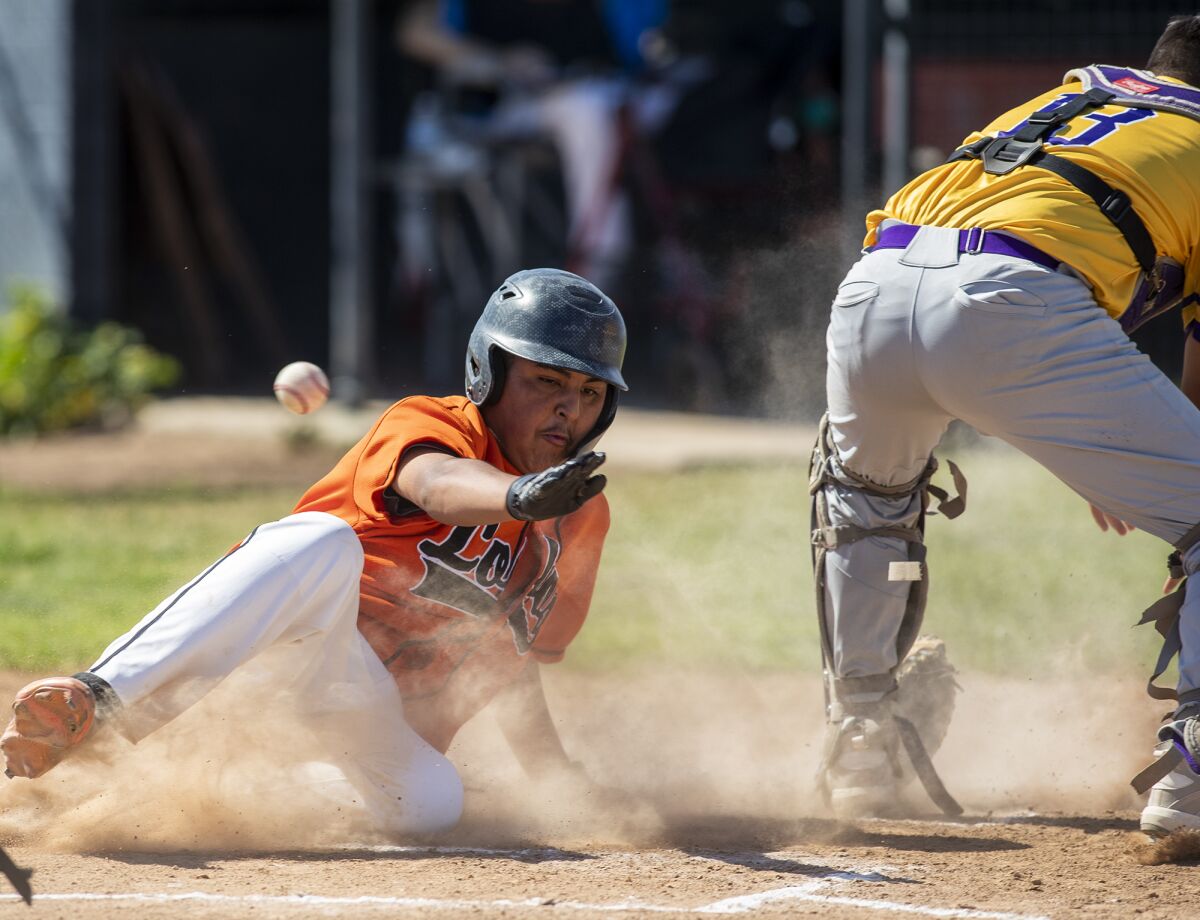 Los Amigos' Steven Esteves beats the throw to Santiago's Cesar Lopez and scores on a double by Aaron Ramirez on April 8.