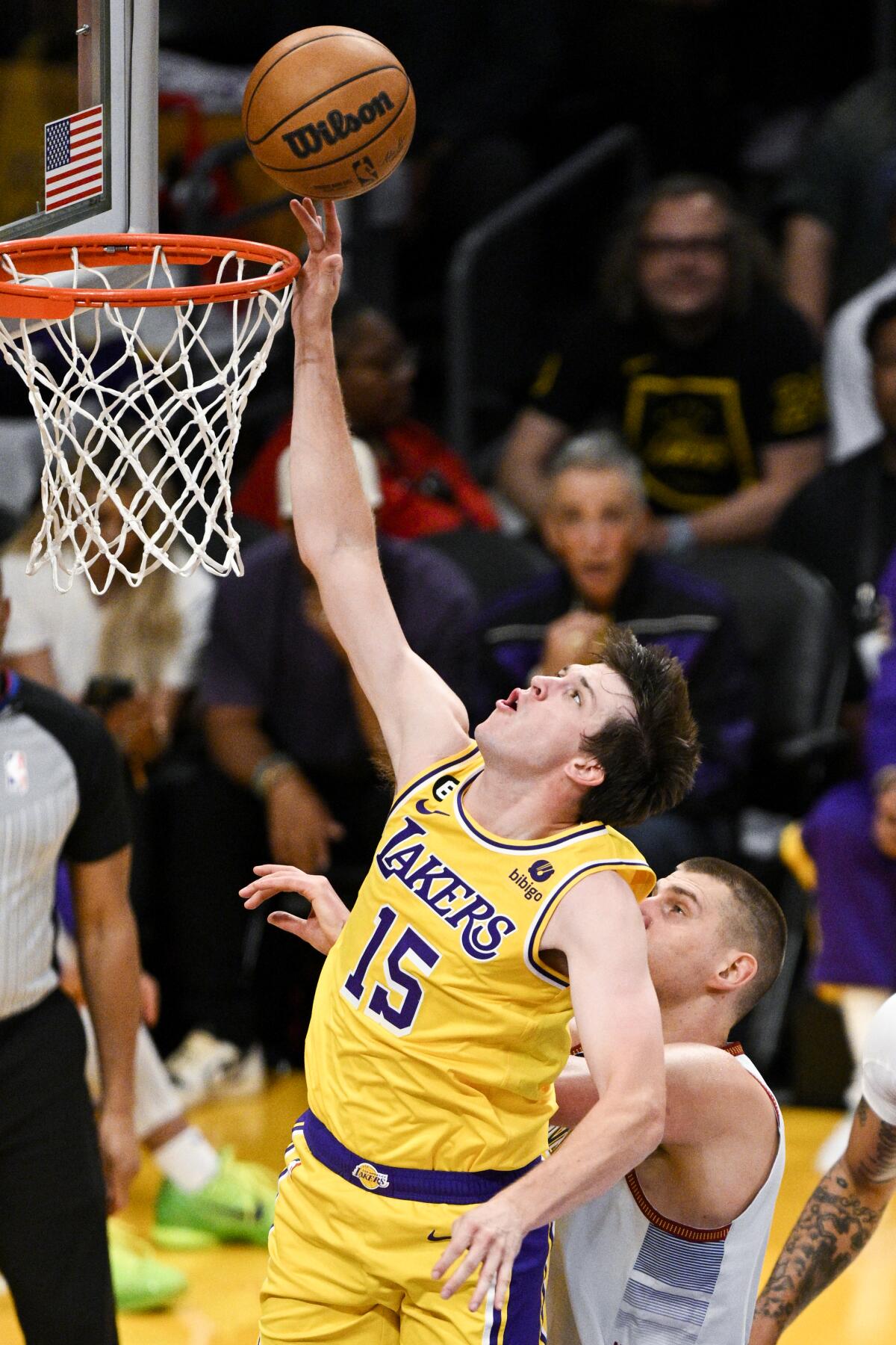 Lakers guard Austin Reaves, left, gets past Nuggets center Nikola Jokic for a layup.