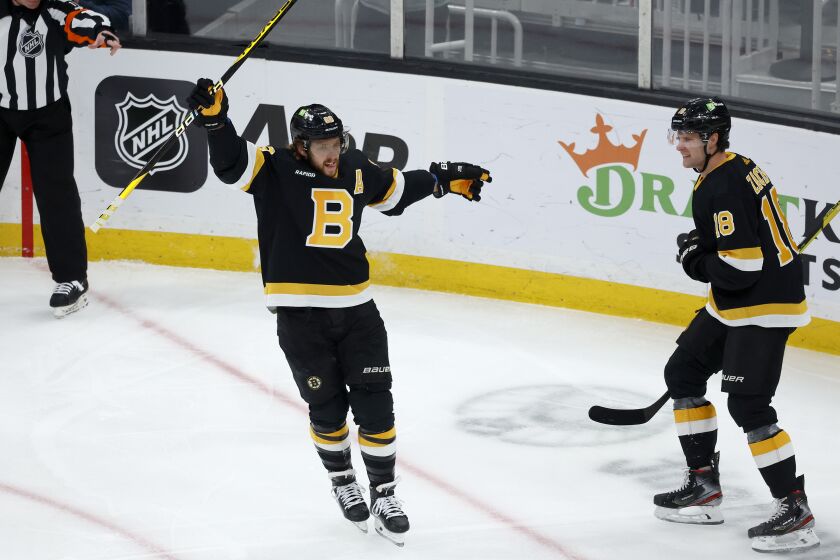Boston Bruins right wing David Pastrnak celebrates with teammate Pavel Zacha (18) after scoring a goal during the first period of an NHL hockey game against the Philadelphia Flyers, Monday, Jan. 16, 2023, in Boston. (AP Photo/Mary Schwalm)