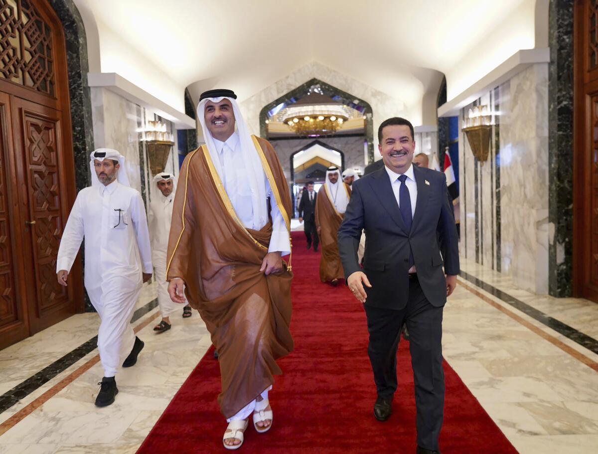 This photo from Iraqi Government, Iraqi Prime Minister Mohammed Shia al-Sudani, right, welcomes Qatar Sheikh Tamim bin Hamad Al Thani, in Baghdad, Iraq, Thursday, June 15, 2023. The two countries signed a broad agreement to expand "cooperation in politics, economics, energy, and investment," Sudani said in a statement. (Iraqi Prime Minister Media Office via AP)