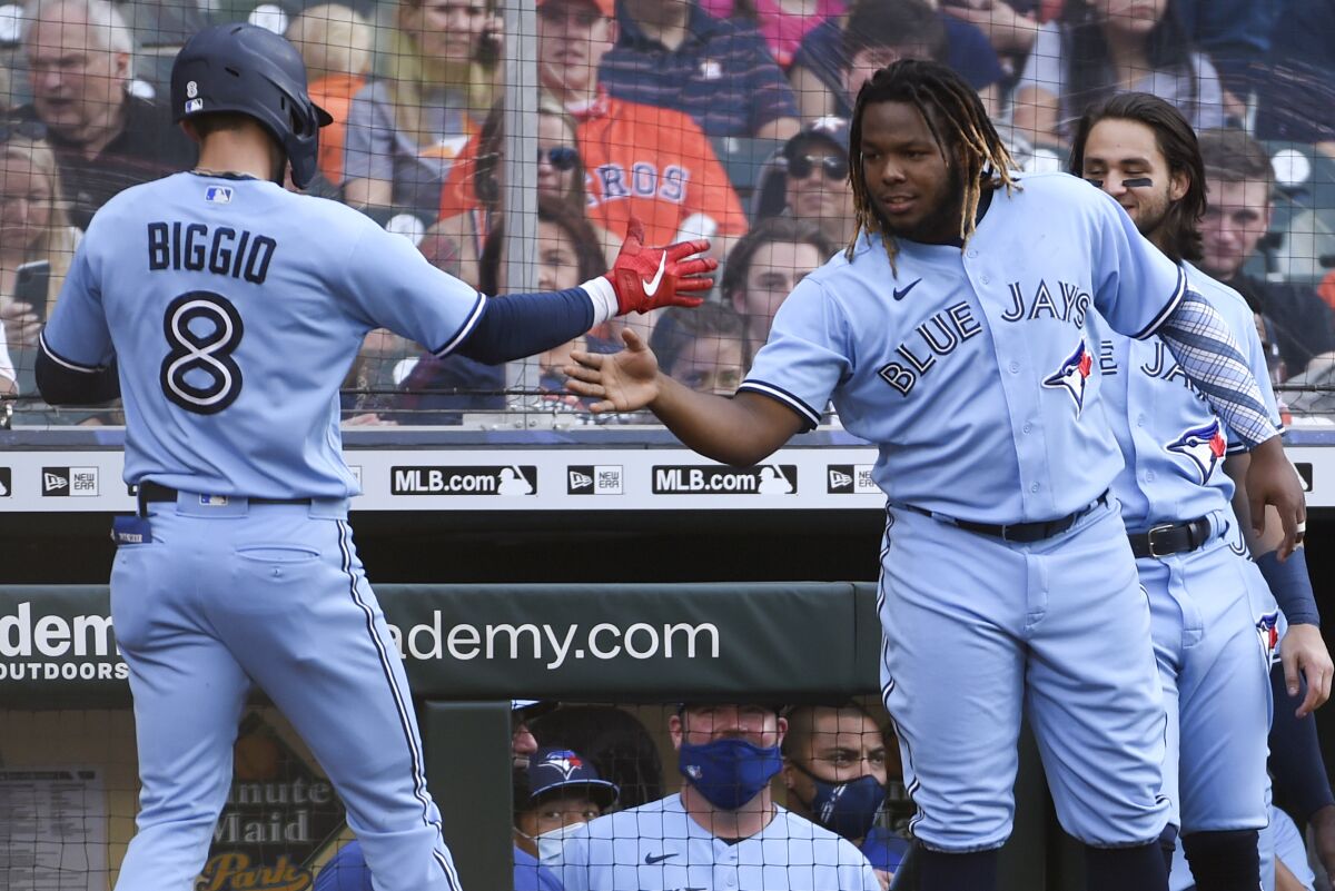 Toronto Blue Jays' Cavan Biggio (8) celebrates with Vladimir Guerrero Jr. as Biggo returns to the dugout after hitting a two-run home run during the second inning of the team's baseball game against the Houston Astros, Saturday, May 8, 2021, in Houston. (AP Photo/Eric Christian Smith)