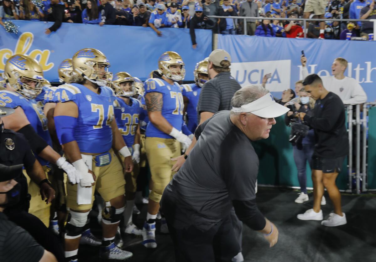 UCLA coach Chip Kelly runs on to the field before a game.