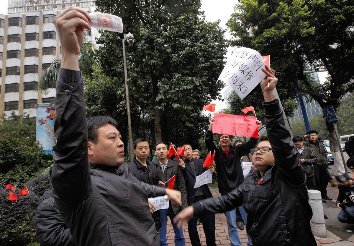A supporter of the Southern Weekly, left, confronts an ideological rival outside the paper's headquarters in Guangzhou, China.