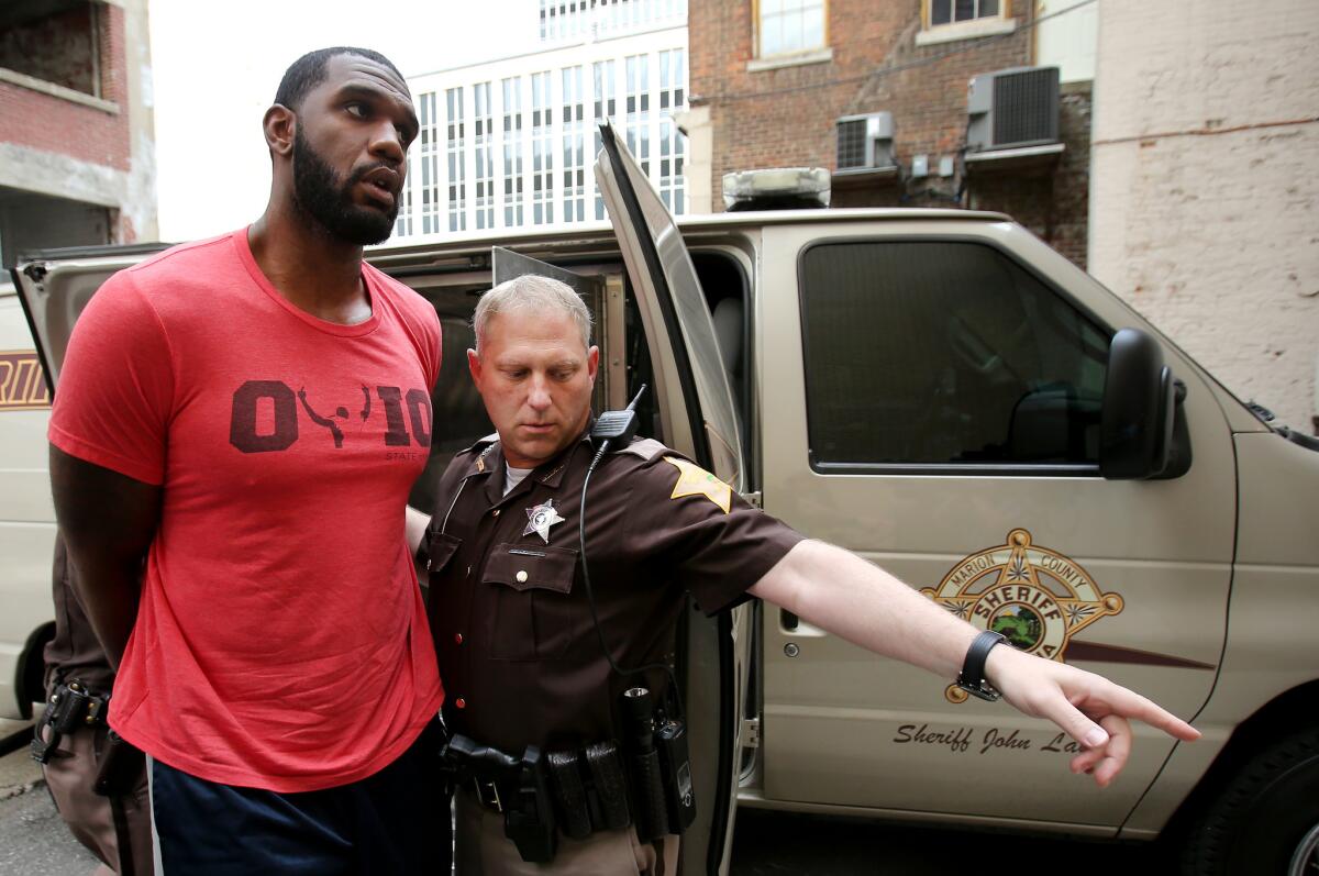 Greg Oden is escorted into the Marion County Community Corrections building in Indianapolis.