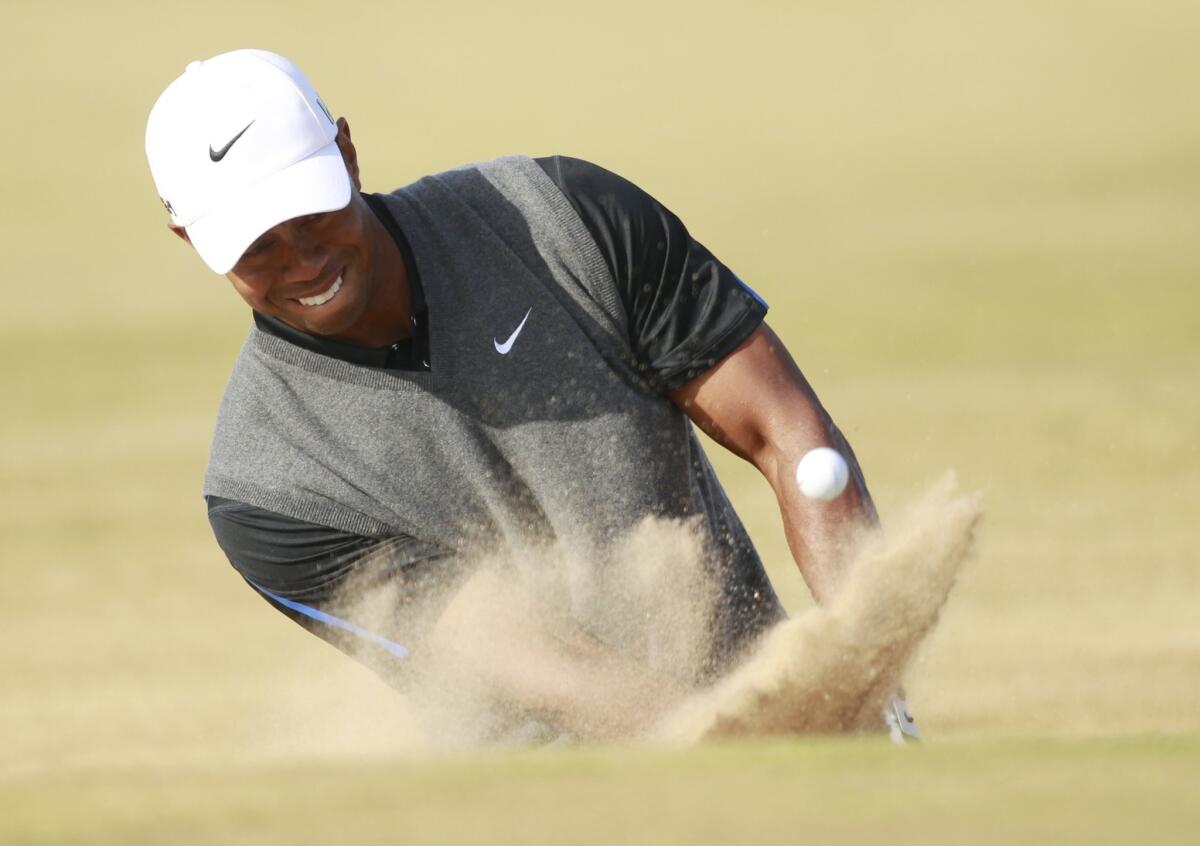 Tiger Woods plays out of a bunker onto the 14th green during the third round of the British Open on Saturday.