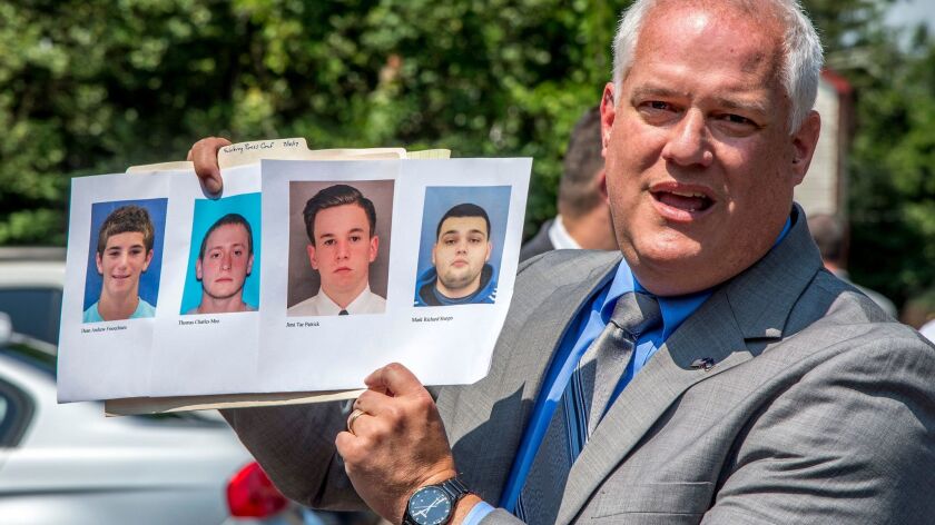 Bucks County Dist. Atty. Matthew Weintraub holds photos of the four missing men at a news conference in Solebury Township, Pa., on July 10, 2017.