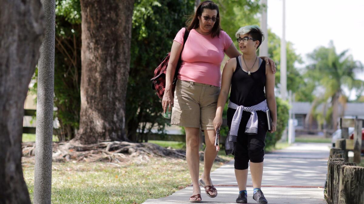 Imagen de abril del año pasado de Theo Ramos, entonces de 14 años, acompañado de su madre Lori, en una calle de su vecindario en Homestead, Florida.
