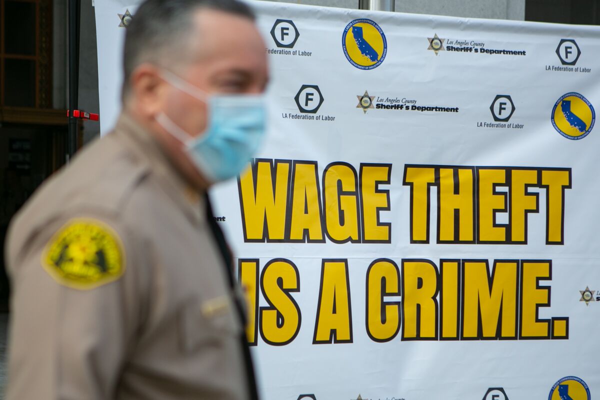 L.A. County Sheriff Alex Villanueva in front of a banner that says "Wage theft is a crime"
