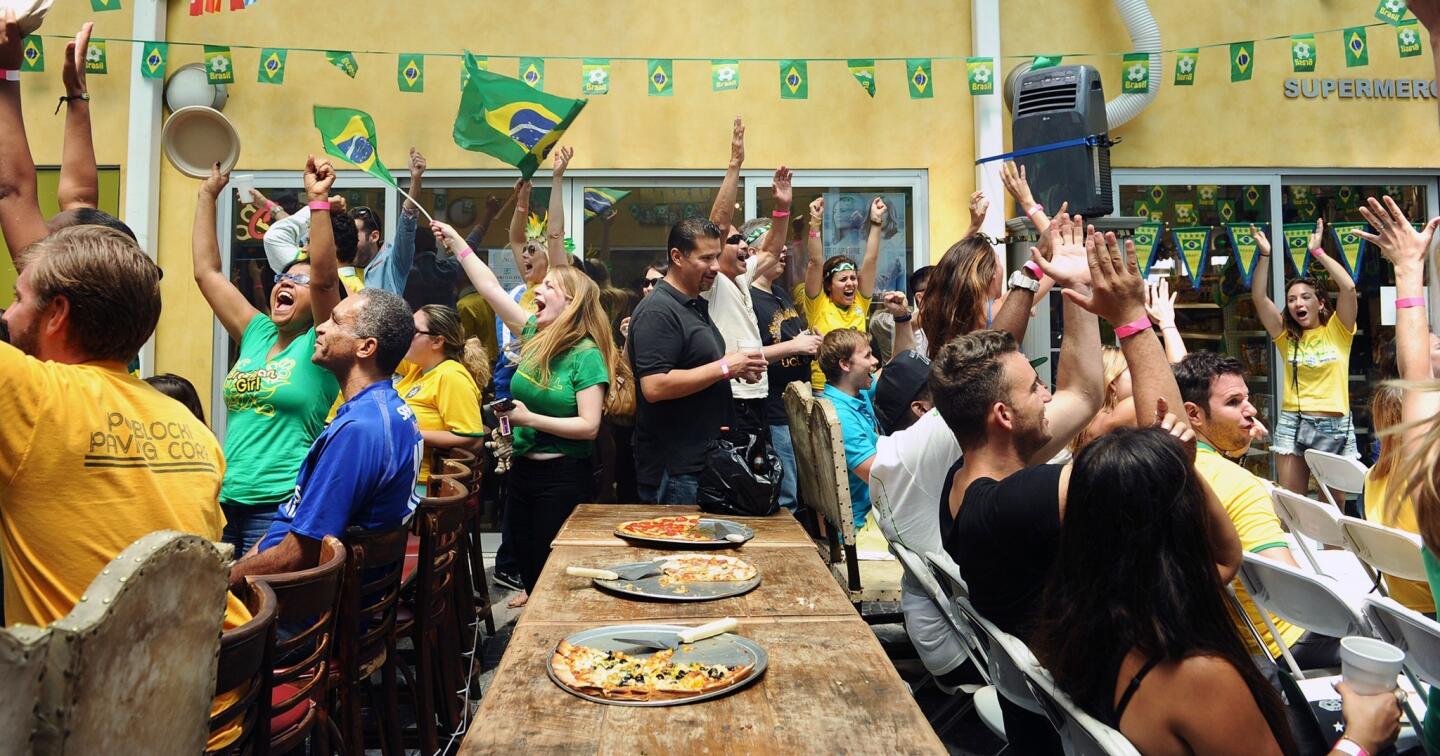 Fans react to a goal as they watch a World Cup match between Brazil and Cameroon at the Brazilian Mall.
