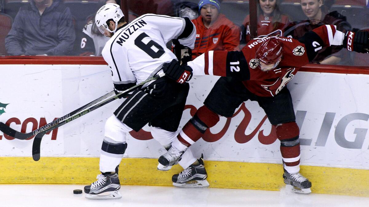 Kings defenseman Jake Muzzin battles Coyotes winger Brad Richardson for the puck in the first period Saturday.