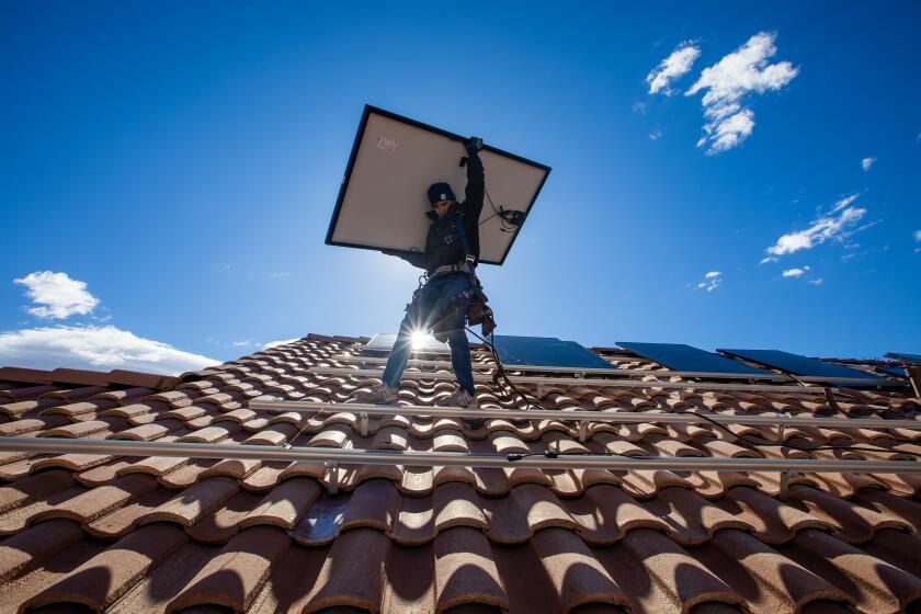 Las Vegas, NV - January 23: Employees of Sunrun, nation's largest rooftop solar installer carry panels into position in North Las Vegas, NV. (Brian van der Brug / Los Angeles Times)