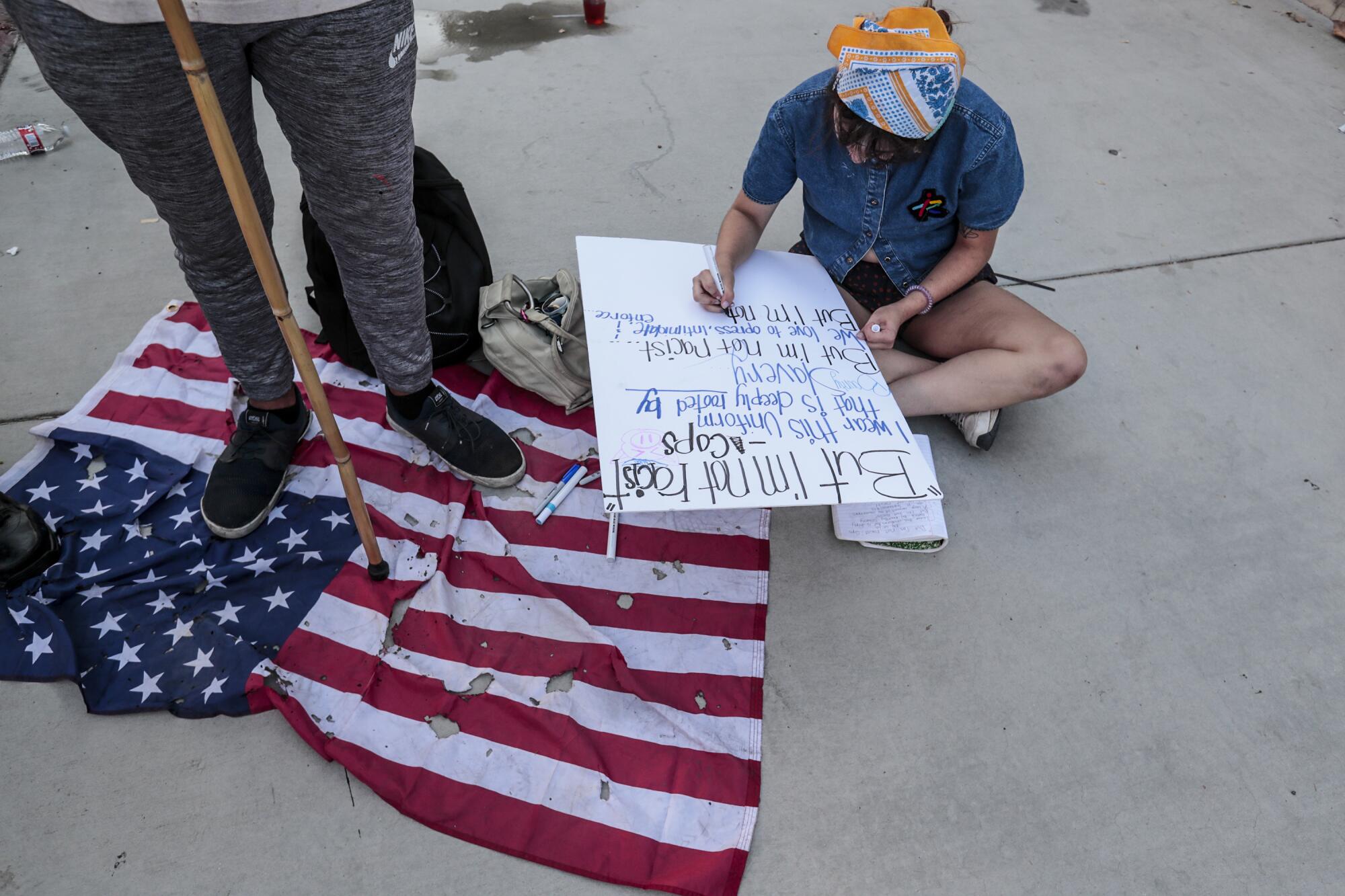 A protester writes a poem on a protest sign in L.A. 