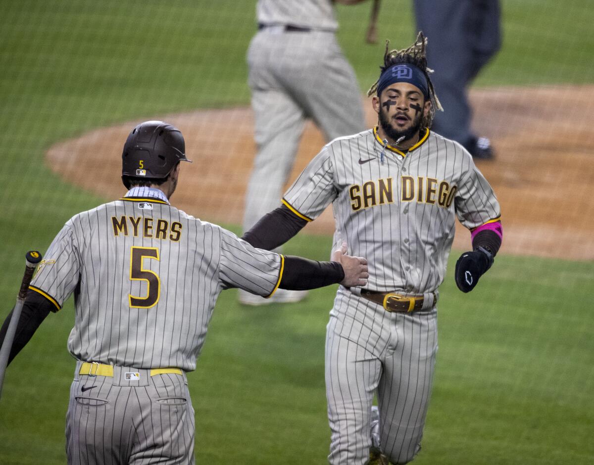 San Diego Padres shortstop Fernando Tatis Jr. gets a hand slap from teammate Wil Myers.