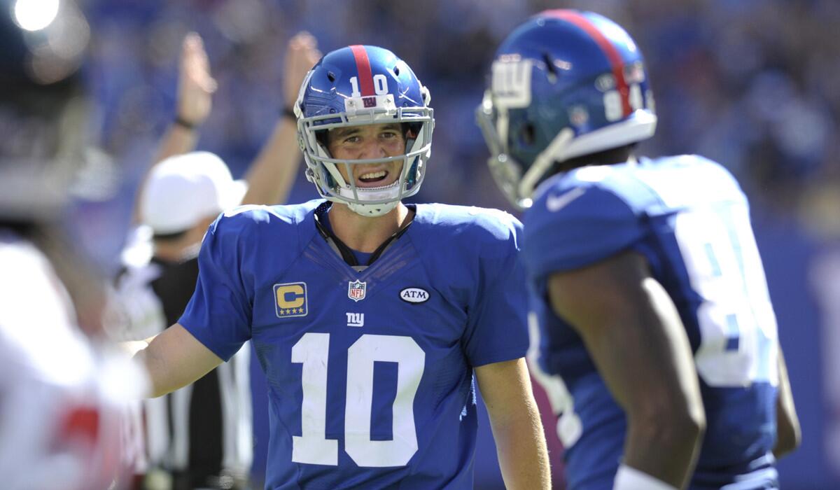 New York Giants quarterback Eli Manning (10) talks with tight end Larry Donnell during the first half against the Atlanta Falcons on Sunday.