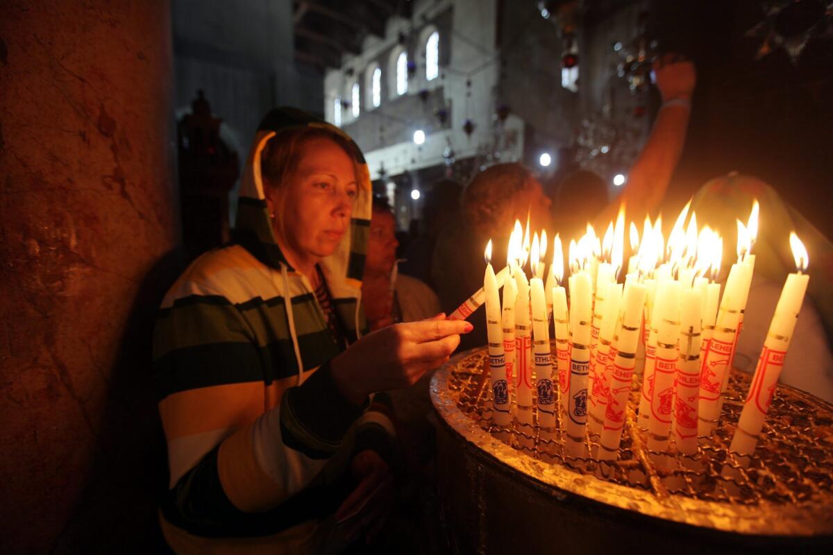 A woman lights candles in the Church of the Nativity in the West Bank city of Bethlehem, where tradition says Jesus was born. The city will be added to the itineraries of Viking Ocean Cruises.