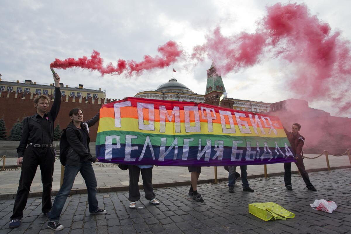 Activists hold a rainbow banner reading "Homophobia — the religion of bullies" in Red Square in Moscow nearly a decade ago.