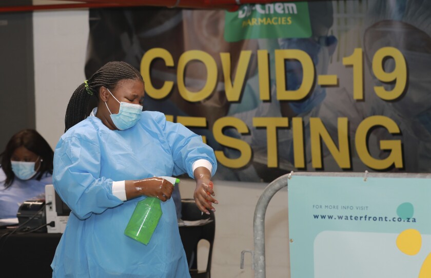 A health-care worker sanitises her hands before conducting COVID-19 tests at a Dis-Chem drive-through testing station at the V&A Waterfront in Cape Town, South Africa, Friday, Jan. 8, 2021. South Africa with 60 million people has reported by far the most cases of the coronavirus in Africa, with more than 1.1 million confirmed infections. (AP Photo/Nardus Engelbrecht)