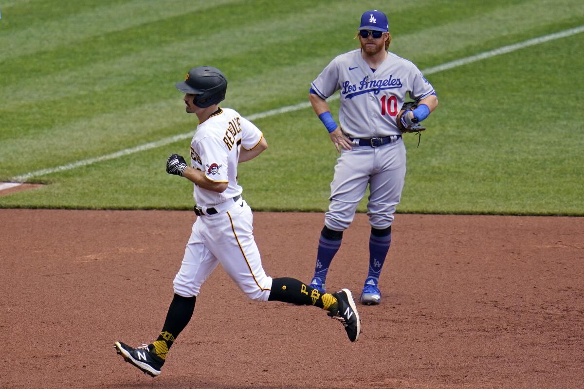 Pittsburgh's Bryan Reynolds rounds third base past Dodgers third baseman Justin Turner.