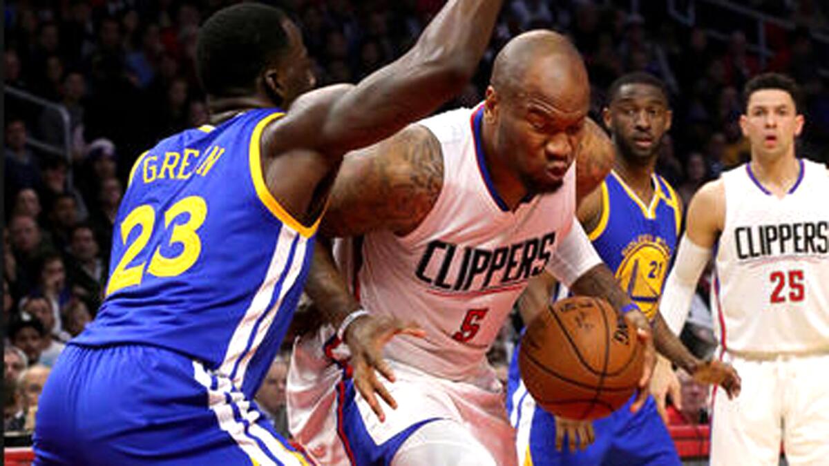 Clippers forward Marreese Speights drives to the basket against Warriors forward Draymond Green during the first quarter Wednesday.