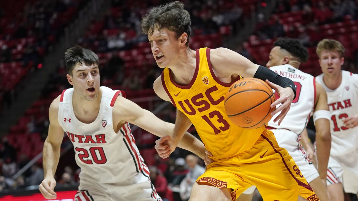 USC guard Drew Peterson (13) drives to the basket in front of Utah guard Lazar Stefanovic.