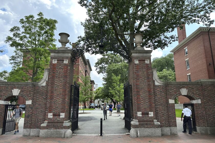 Estudiantes cruzan una puerta en la Universidad Harvard, el jueves 29 de junio de 2023, en Cambridge, Massachusetts. (AP Foto/Michael Casey)