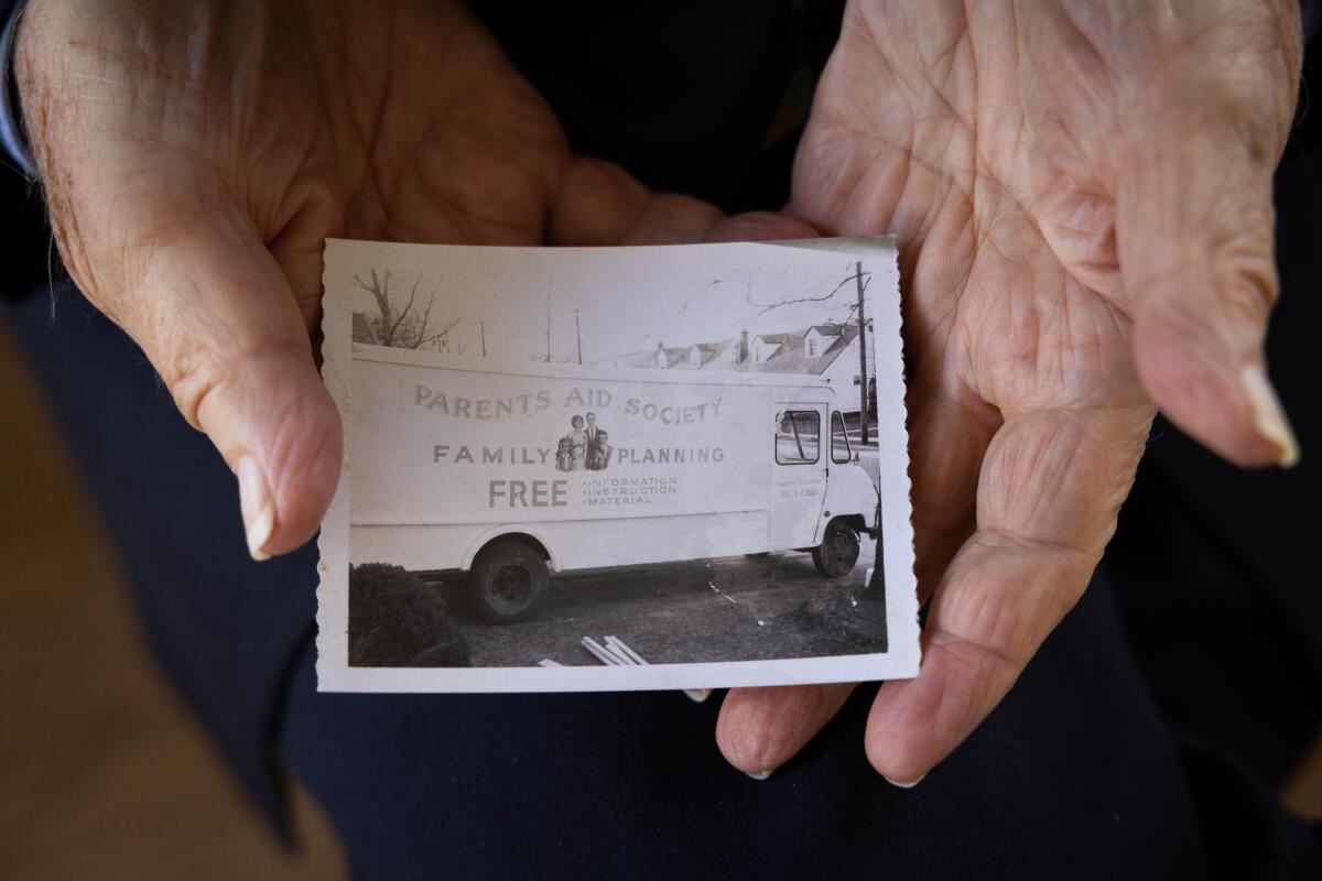 Bill Baird holds a photograph of his mobile clinic, which he created in a 25-foot van and drove into communities to provide free health info and hand out free birth control.