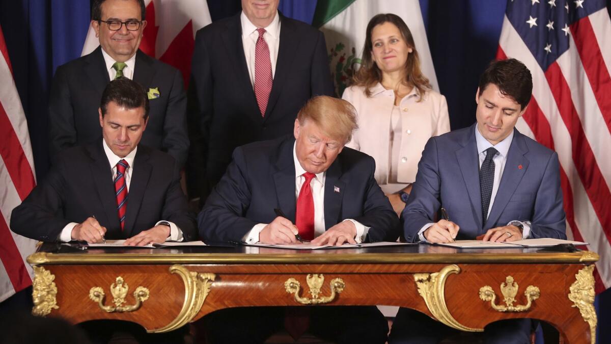Mexican President Enrique Peña Nieto, left, President Trump and Canadian Prime Minister Justin Trudeau sign their countries' new trade deal Nov. 30. The deal is awaiting approval from the countries' legislatures.