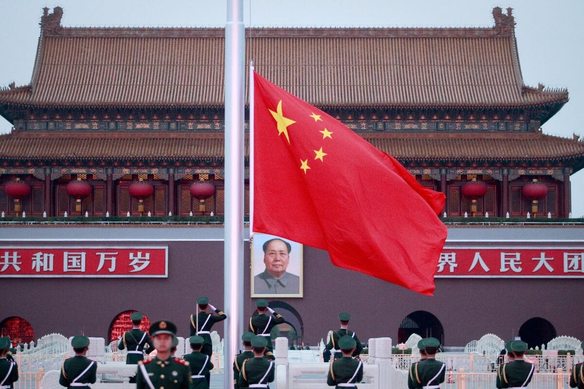 Members of the People's Liberation Army lower the flag on Tiananmen Square during a ceremony at the Gate of Heavenly Peace on the eve of the 18th Communist Party of China Congress in Beijing, China.