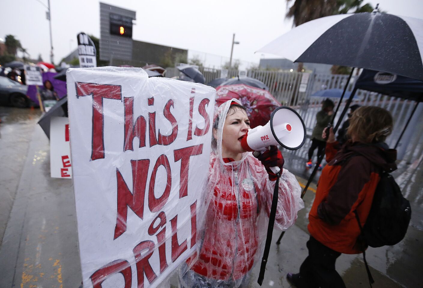 Counselor Leah Zeller leads teachers as they chant in the rain on the picket line at Robert F. Kennedy Community Schools in Los Angeles.