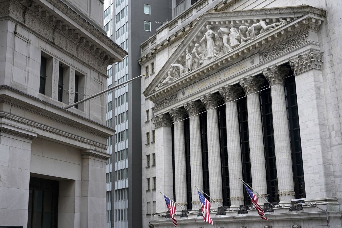 Three U.S. flags hang from the front of the New York Stock Exchange.
