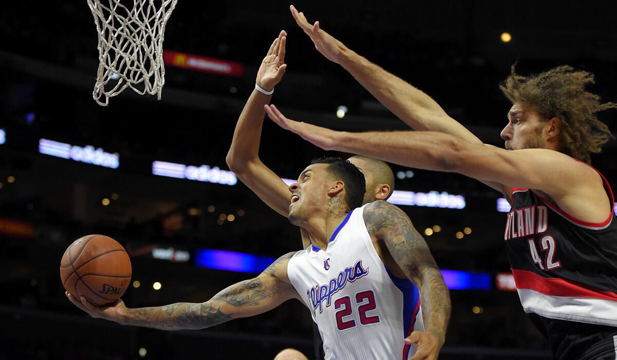 Clippers forward Matt Barnes (22) tries to score against Trail Blazers forward Nicolas Batum and center Robin Lopez (42) in the first half Friday night at Staples Center.