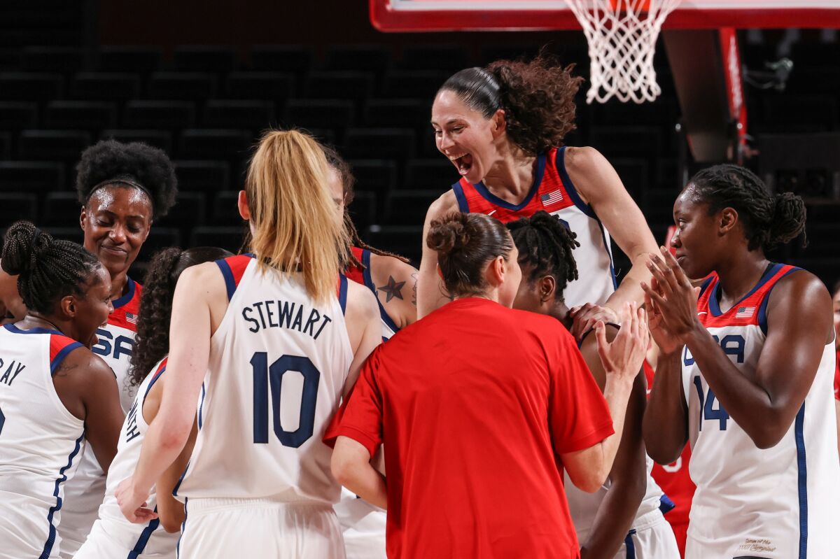 Players on the U.S. women's basketball team celebrate after beating Japan to win the gold medal.