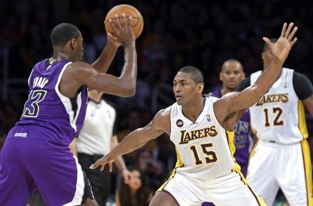 Lakers forward Metta World Peace plays tight defense on Kings point guard Tyreke Evans in the first half Sunday night at Staples Center.