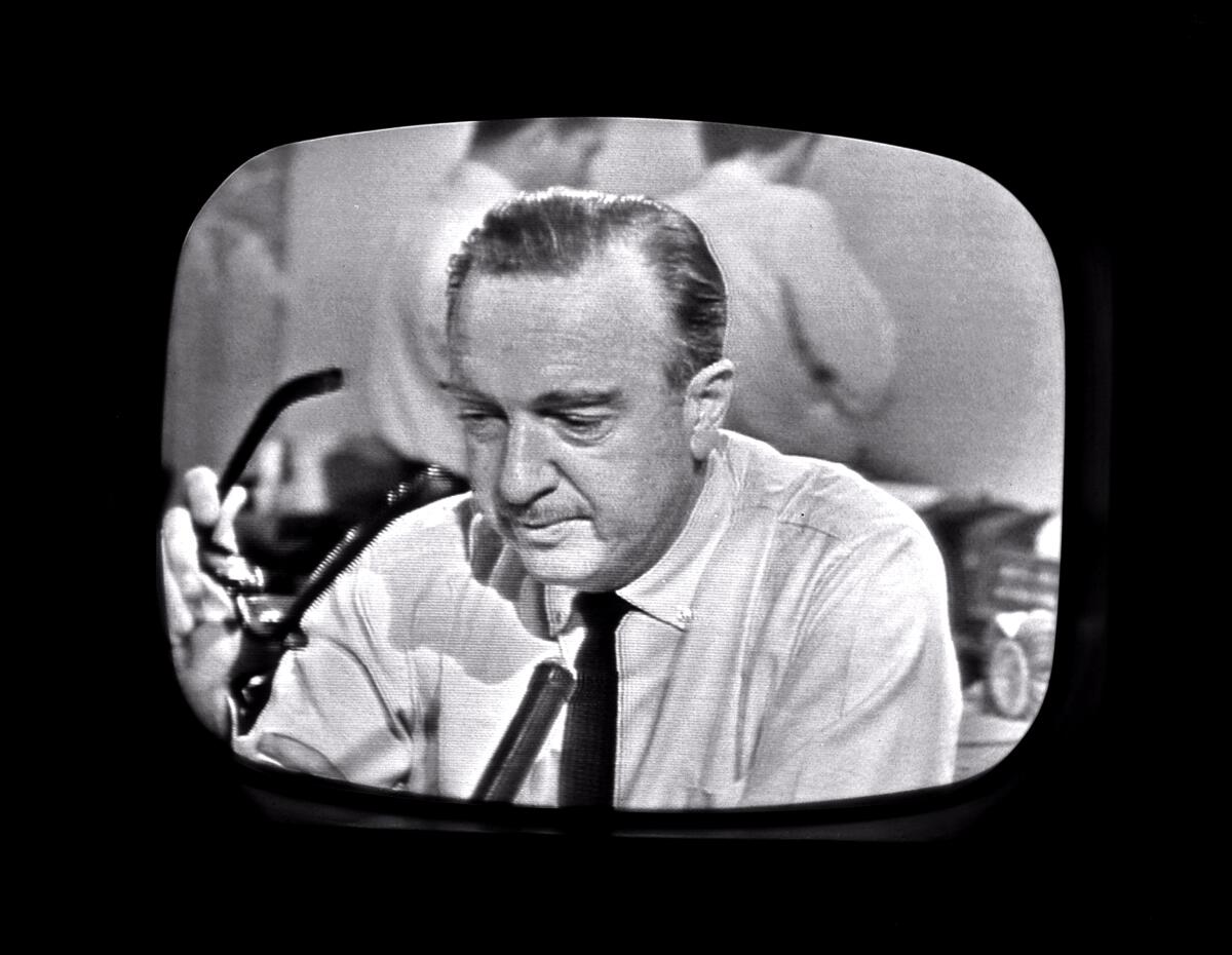 A black-and-white image of Walter Cronkite as he removes his glasses.  