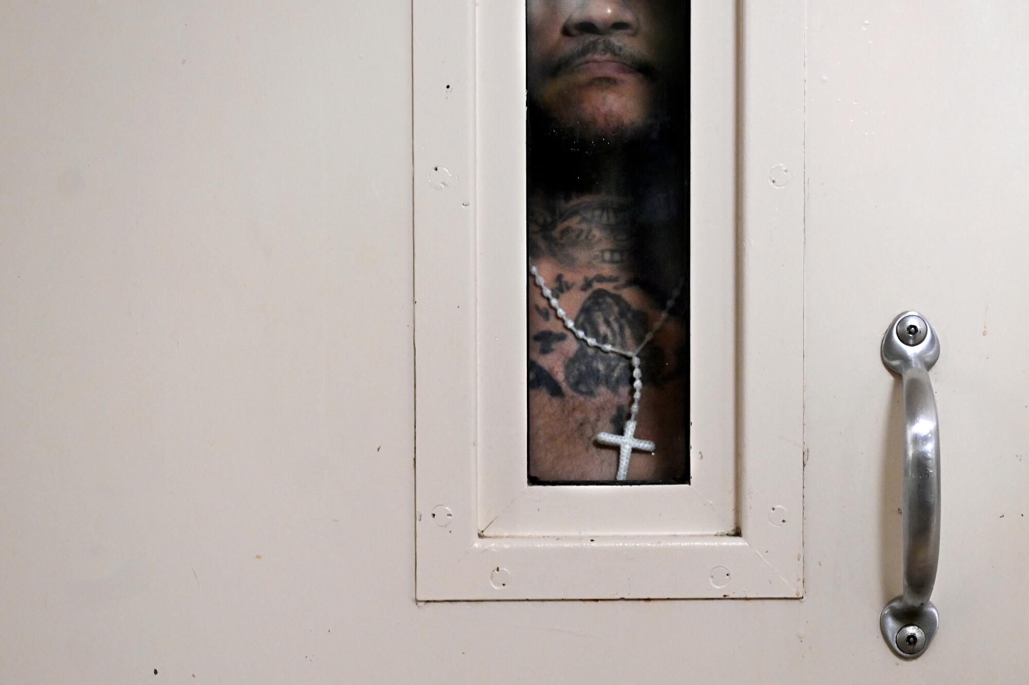 An inmate looks out of a jail cell.