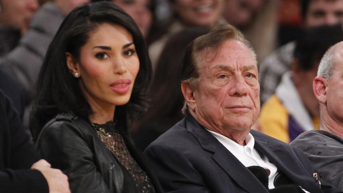 Clippers owner Donald Sterling, right, and V. Stiviano watch the Clippers play the Lakers in a 2010 preseason game. What possible steps could the NBA take if it chooses to punish Sterling for racist comments he allegedly made?