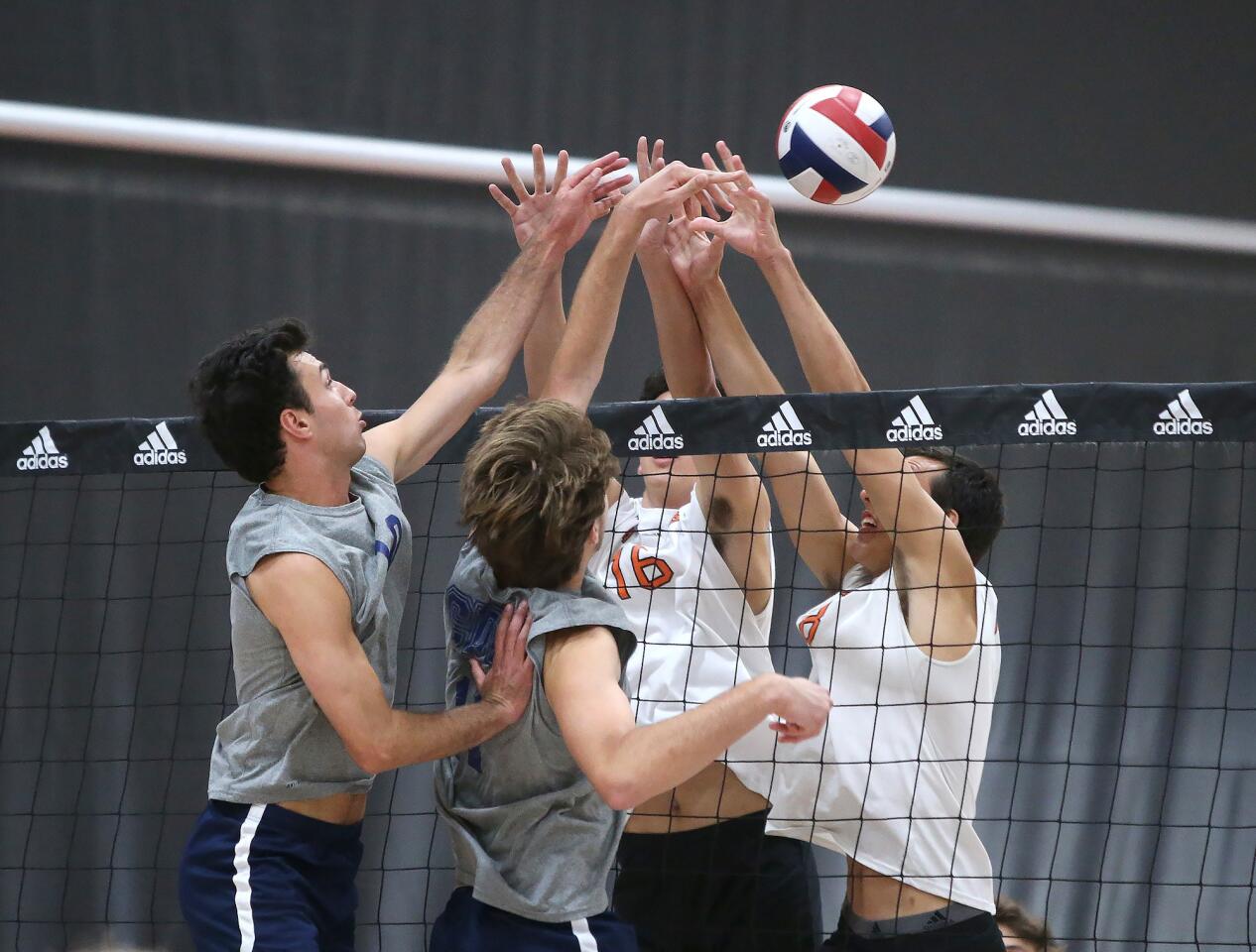 Corona del Mar's Nick Alacano and Glen Linden, battle at the top of the net with Huntington's Trent Doughner(16) and Drake Goering (18) during Surf League volleyball match on Saturday.