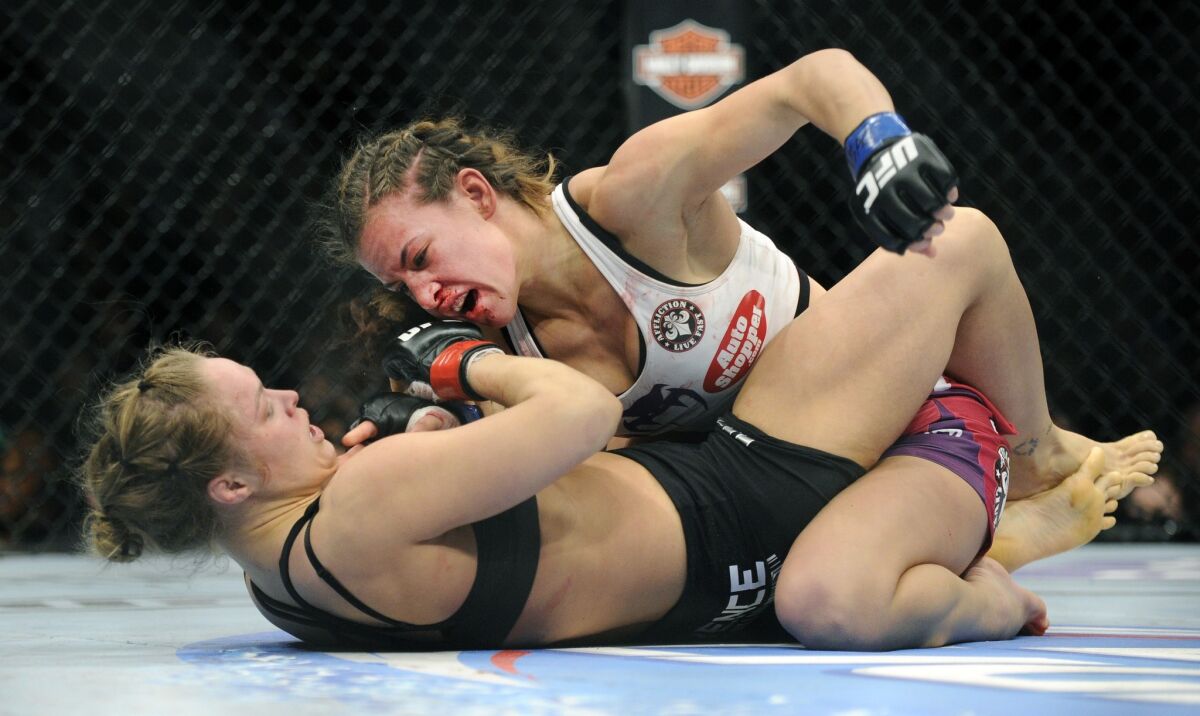 Miesha Tate, top, punches Ronda Rousey during their bantamweight title fight at UFC 168 in Las Vegas in 2013.
