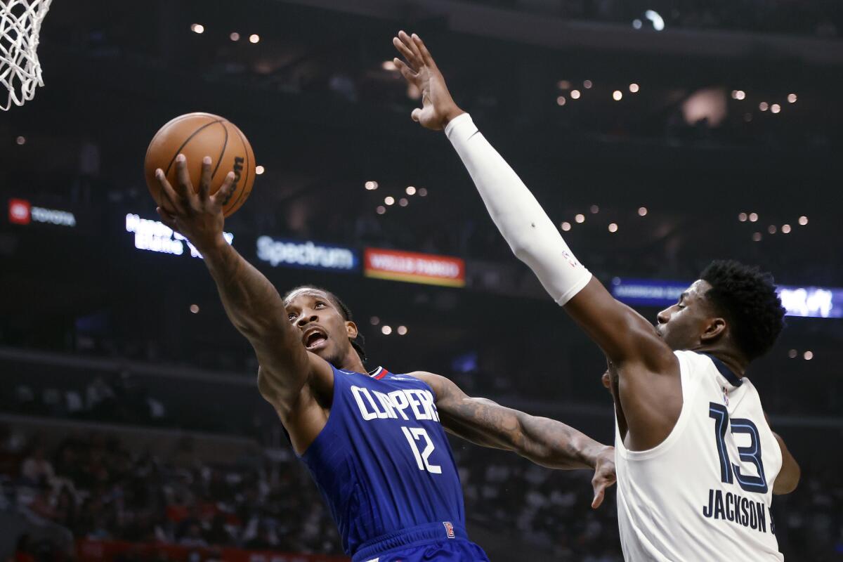 Clippers guard Eric Bledsoe attempts a layup while defended by Grizzlies forward Jaren Jackson Jr.