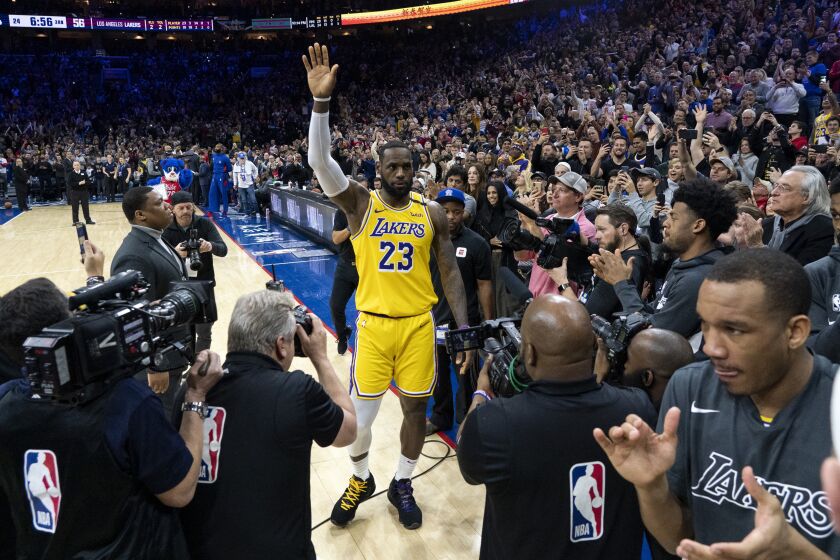 Lakers forward LeBron James acknowledges the fans' ovation after passing Kobe Bryant for No. 3 on the NBA's all-time scoring list during a game Jan. 25, 2020, in Philadelphia.