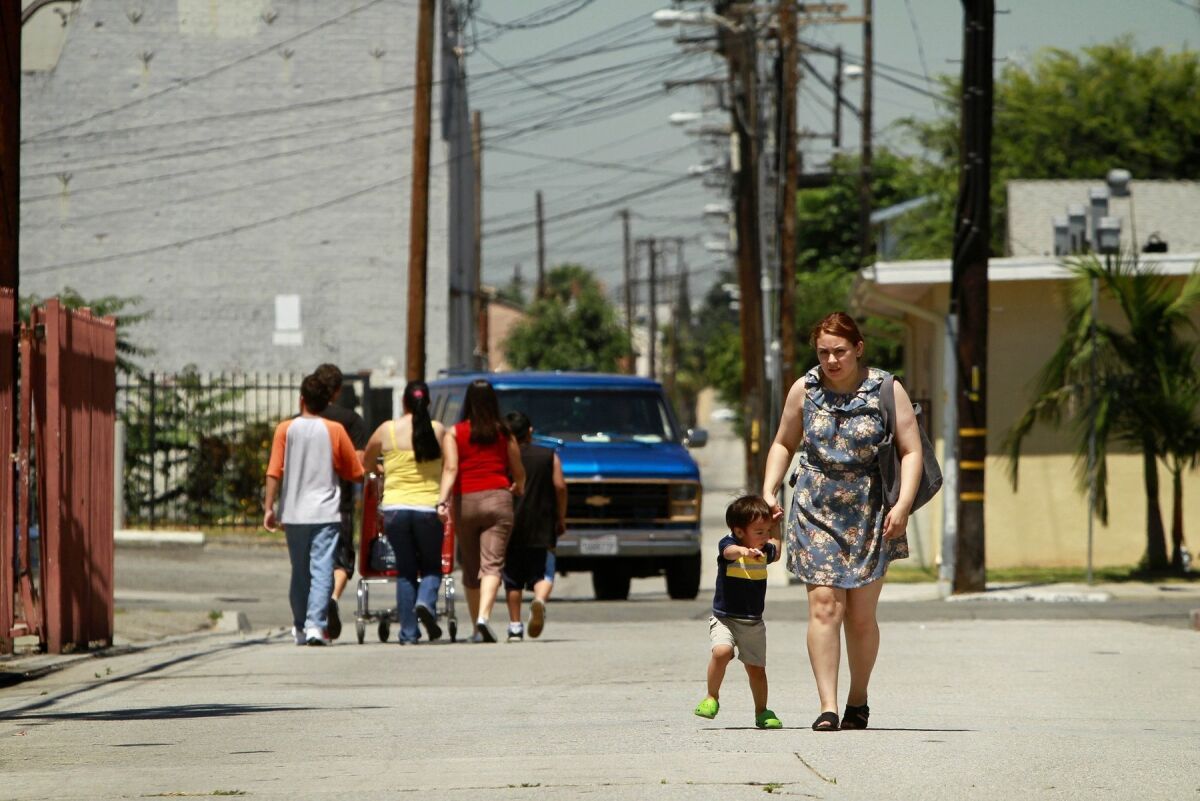 Angie Rivera walks with nephew Nikolia De Anda near Bell City Hall. Many residents of the city of 40,000 people are angry about the high salaries paid to City Council members and city officials.
