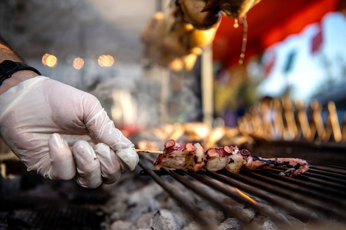 Chef Kostas Katsaros of Calamaki prepares octopus for one of his bestselling octopus skewers at the Altadena Farmers Market.