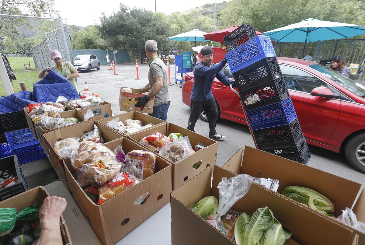 Volunteers keep things moving at the Laguna Food Pantry, which is as busy as ever, on Wednesday.