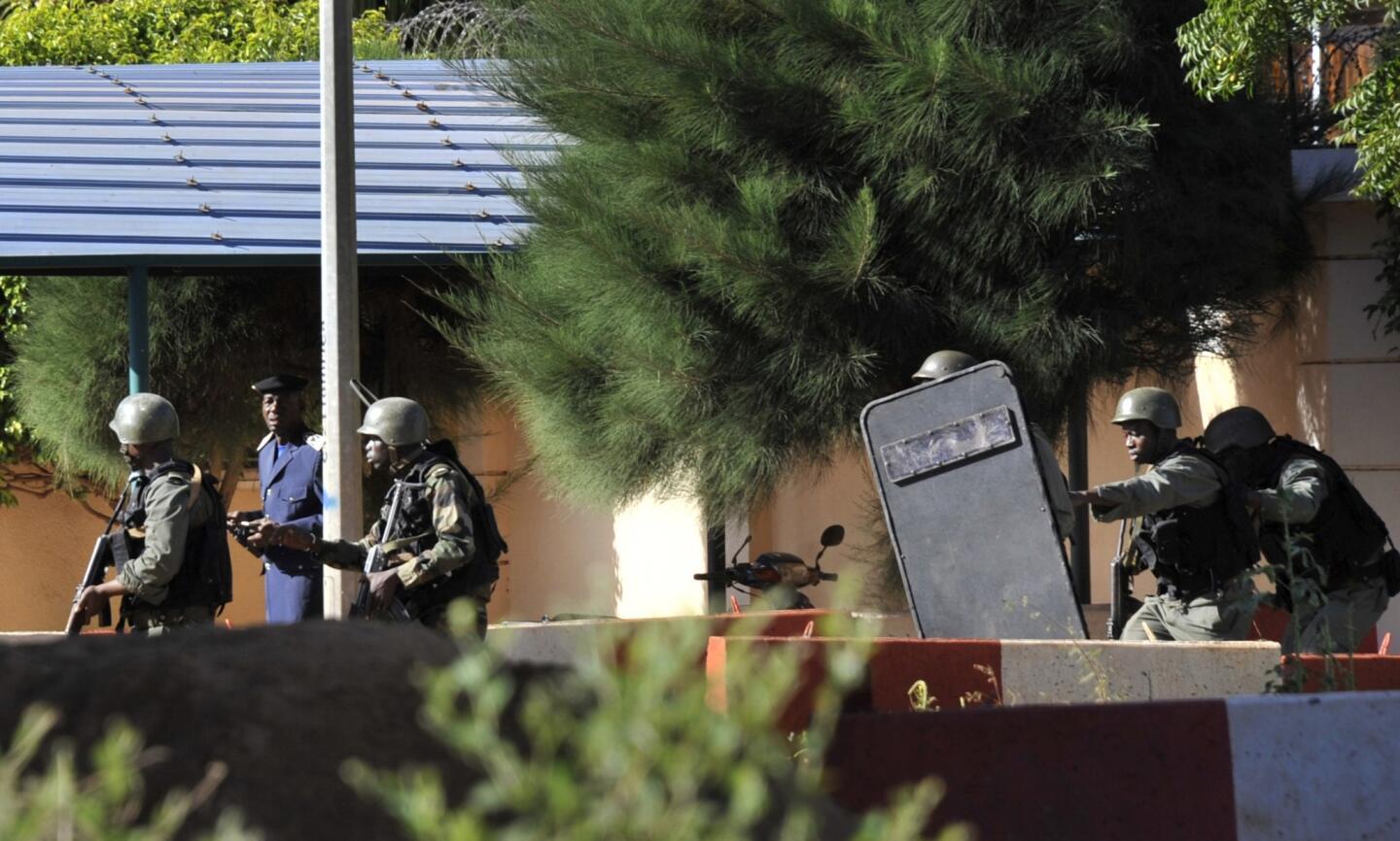Malian troops take position outside the Radisson Blu hotel in Bamako. Gunmen went on a shooting rampage at the luxury hotel in Mali's capital, seizing 170 guests and staff. At least three people are dead.