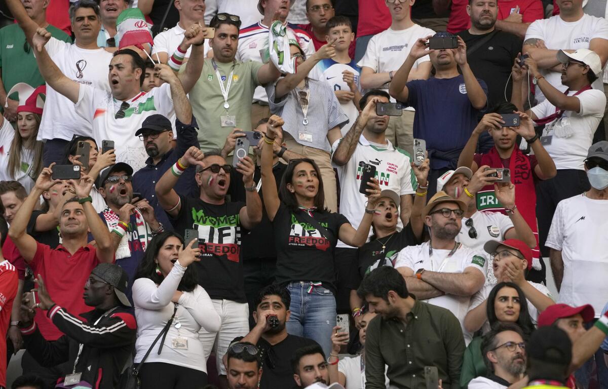 Supporters of Iran's soccer team react during the country's national anthem Monday in in Doha, Qatar.
