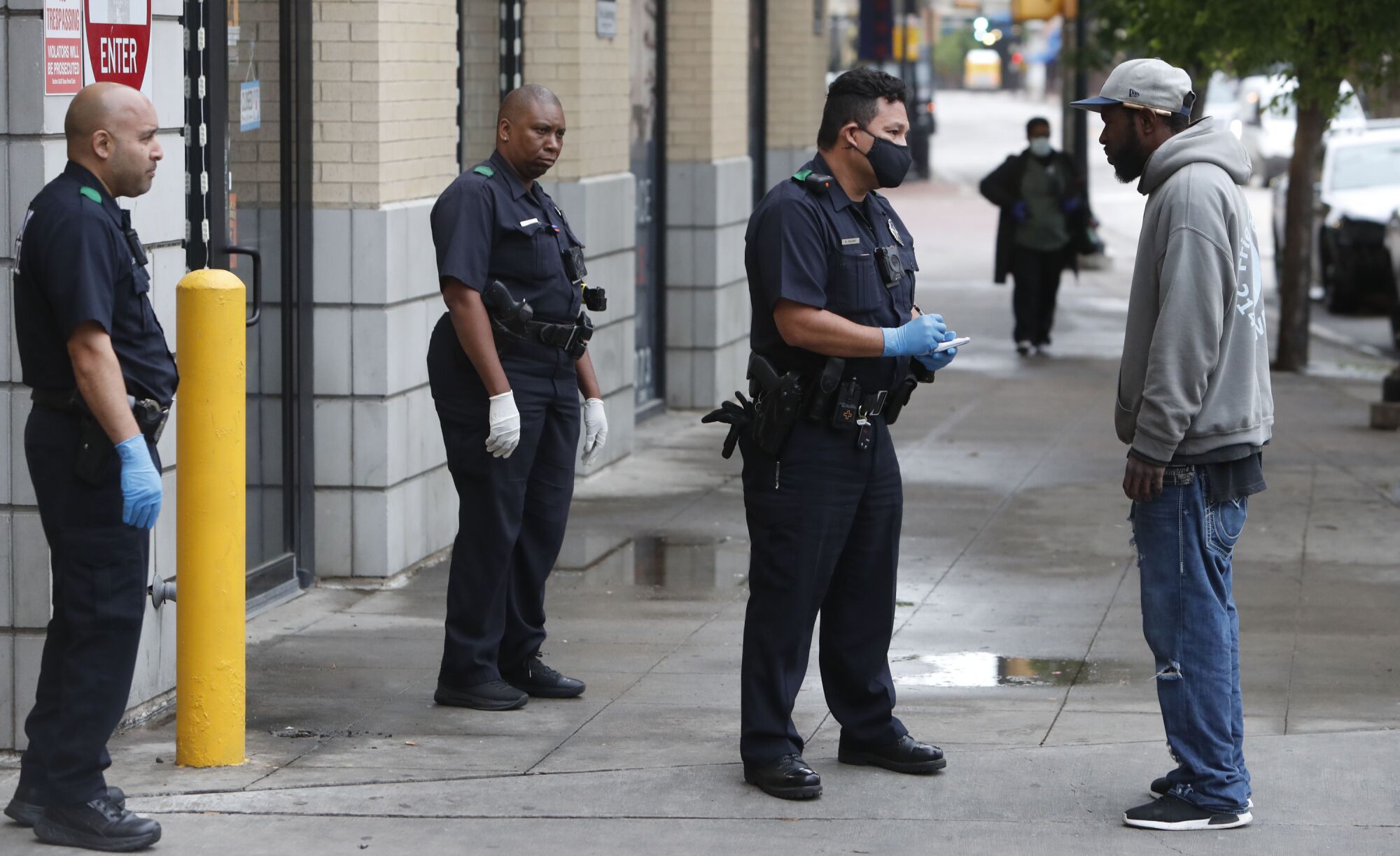 TEXAS: Practicing social distancing amid coronavirus concerns, police officers speak with a man in downtown Dallas.