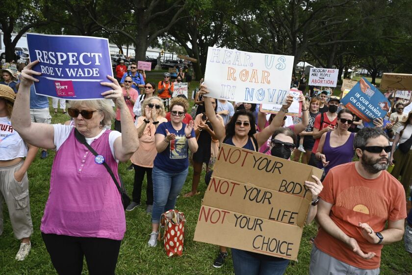 Protesters listen to speeches and display their signs on Friday, June 24, 2022, at North Straub Park in St. Petersburg, Fla. The Supreme Court on Friday stripped away women’s constitutional protections for abortion, a fundamental and deeply personal change for Americans' lives after nearly a half-century under Roe v. Wade. The court’s overturning of the landmark court ruling is likely to lead to abortion bans in roughly half the states. (Jefferee Woo/Tampa Bay Times via AP)